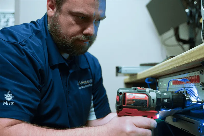 MITS tech working on a computer